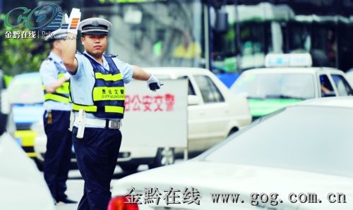 贵阳交警在车流中疏散交通，为考生提供畅通的道路